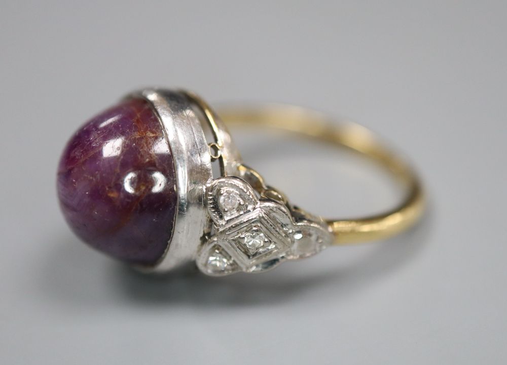 An 18ct and plat, cabochon purple star sapphire set ring, with diamond set shoulders, size N, gross 7.3 grams.